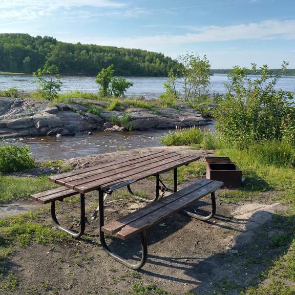 Picnic table and fire pit at Whitemouth Falls Provincial Park