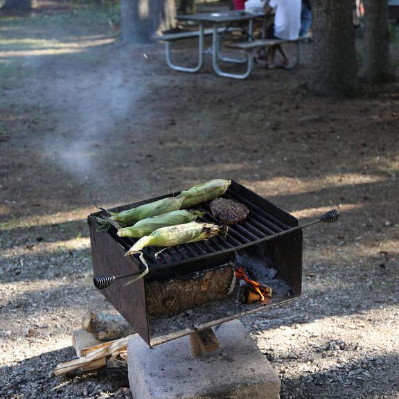 Dinner being cooked on a wood grill at Wasagaming