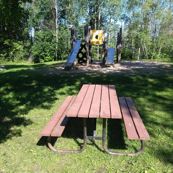 Picnic table and playground at Opapiskaw